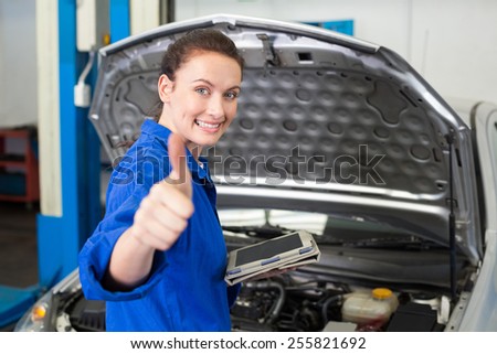 Mechanic using tablet to fix car at the repair garage