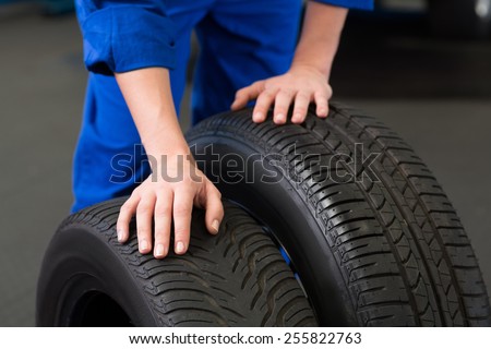 Mechanic rolling a tire wheel at the repair garage