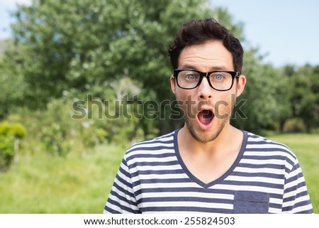 Handsome hipster looking surprised on a sunny day