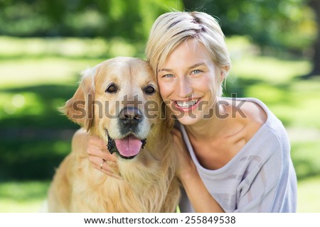 Pretty blonde with her dog in the park on a sunny day