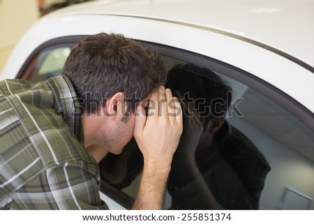 Man looking inside a car at new car showroom