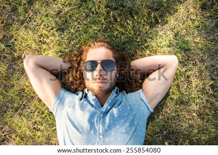 Young man lying down in the park on a summers day