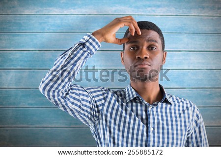 Young businessman thinking against wooden planks