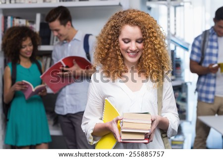 Student carrying small pile of books at the college