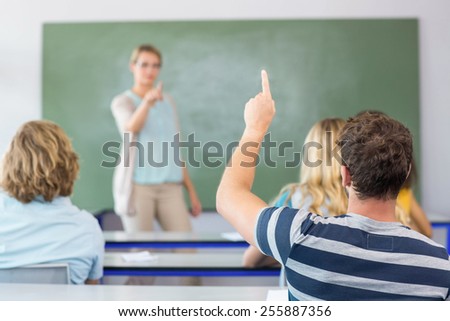 Male student raising hand in the classroom