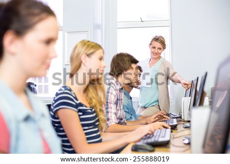 Computer teacher helping students in her class