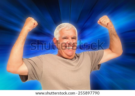 Portrait of a cheerful senior man with clenched fists against abstract background