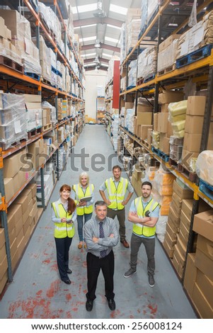 Team standing behind their boss in warehouse