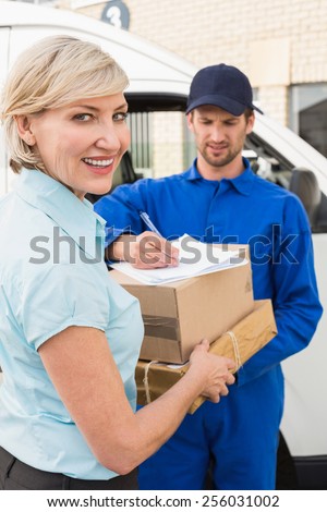 Happy delivery man with customer outside the warehouse