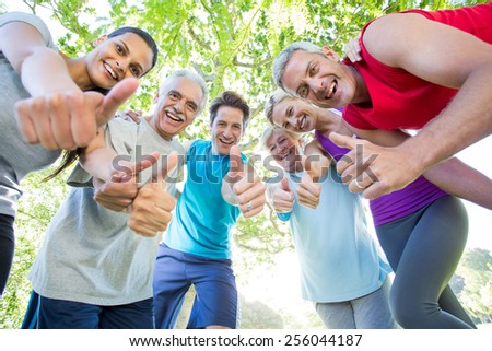 Happy athletic group with thumbs up on a sunny day