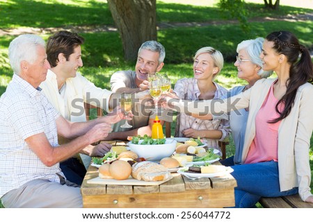 Happy family toasting in the park on a sunny day