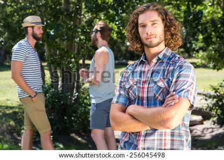 Young man frowning at camera in the park on a summers day