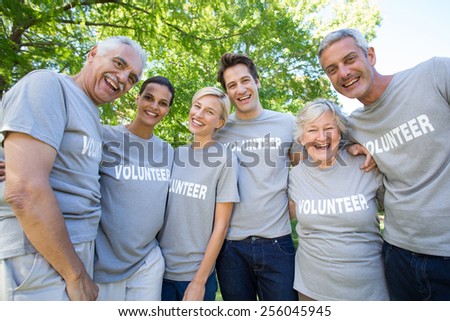 Happy volunteer family smiling at the camera on a sunny day