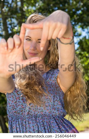Pretty blonde framing with hands on a summers day