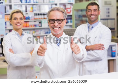 Team of pharmacists smiling at camera at the pharmacy