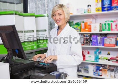 Smiling pharmacist using computer in the pharmacy