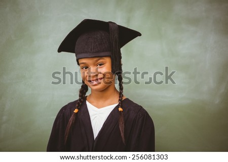 Portrait of cute little girl wearing graduation robe