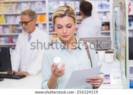 Costumer holding prescription and medicine jar at pharmacy
