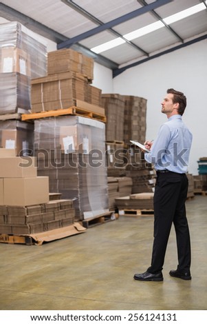 Warehouse manager checking his inventory in a large warehouse