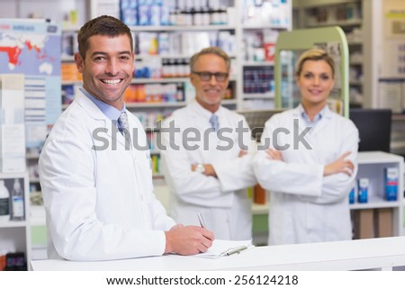 Team of pharmacists smiling at camera at the pharmacy