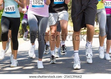 Fit people running race in park on a sunny day