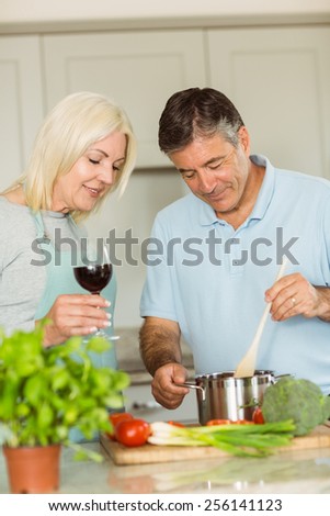 Happy mature couple making dinner together at home in the kitchen