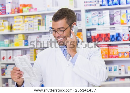 Happy pharmacist on the phone at the hospital pharmacy