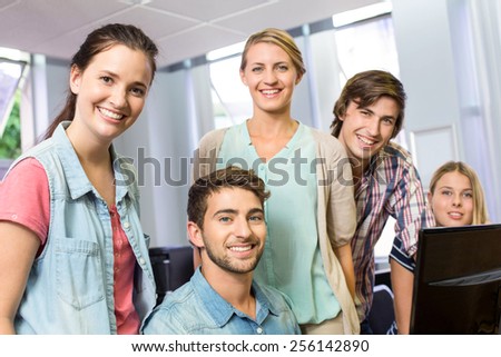Portrait of happy female computer teacher and students in her class