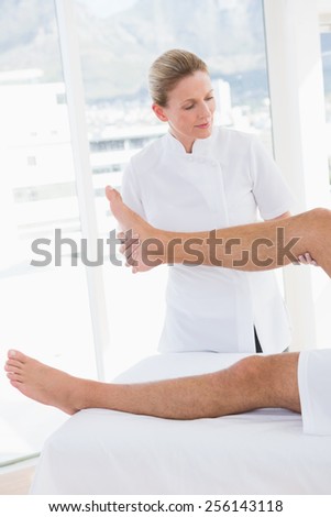Doctor examining man leg in medical office