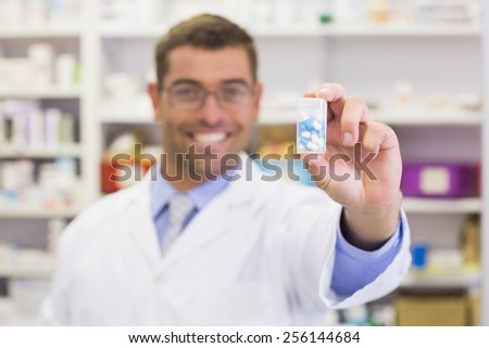 Pharmacist showing medicine jar at the hospital pharmacy