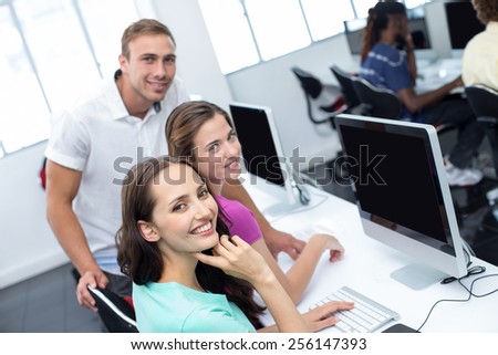 Portrait of computer teacher and pretty female students in his class