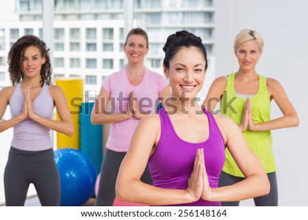 Portrait of happy women with hands joined exercising at gym