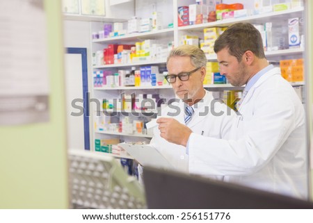 Senior pharmacist reading a prescription on clipboard in the pharmacy