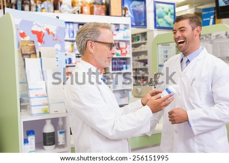 Smiling pharmacists holding medication in the pharmacy