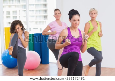 Sporty women practicing kickboxing at fitness studio