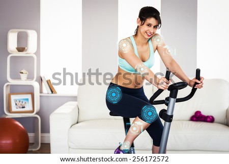 Fit brunette working out on exercise bike against fitness interface