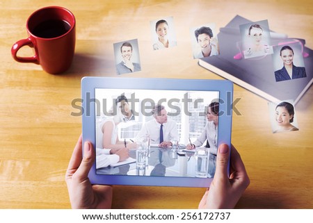 Businesswoman using tablet at desk against serious businessman during a meeting talking to his employees