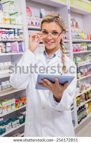 Smiling student using tablet pc in the pharmacy