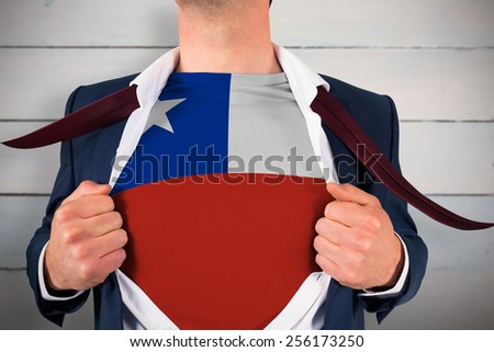 Businessman opening shirt to reveal chile flag against painted blue wooden planks