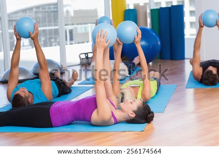 Fit people exercising with medicine ball in fitness studio