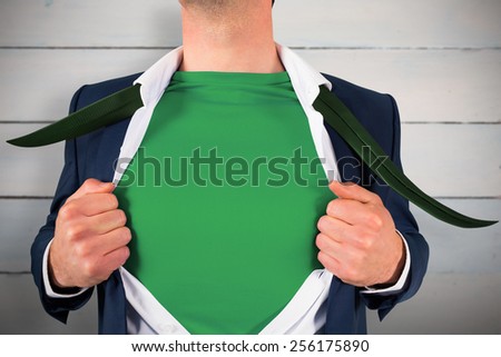 Businessman opening shirt in superhero style against painted blue wooden planks