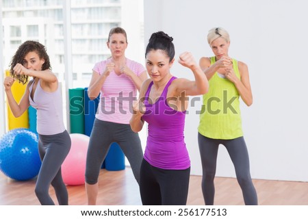 Fit women boxing in air at fitness studio