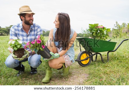 Happy young couple gardening together on a sunny day