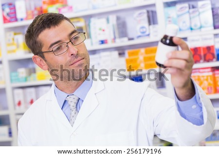Pharmacist holding medicine jar at the hospital pharmacy