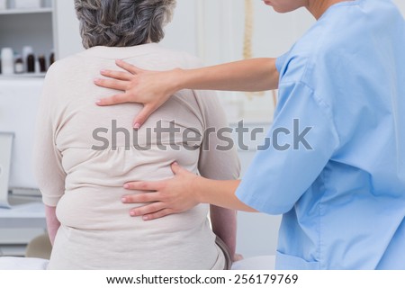 Cropped image of nurse examining female patients back in clinic
