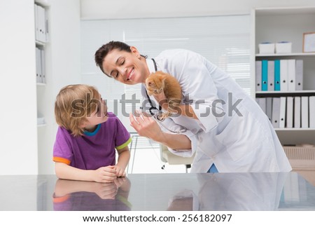 Veterinarian doing injection at a cat with its owner in medical office