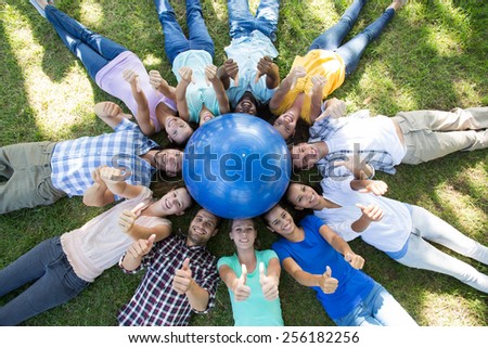 Happy friends in the park lying in circle on a sunny day