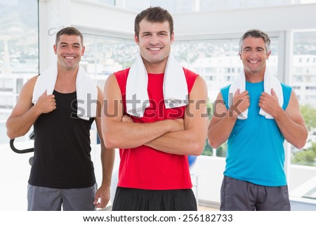 Smiling men looking at camera in fitness studio