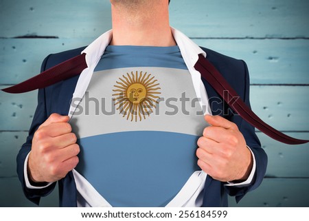 Businessman opening shirt to reveal argentina flag against painted blue wooden planks