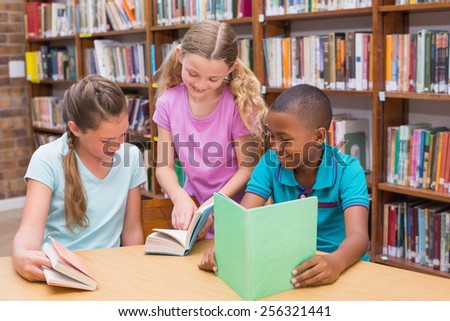 Cute pupils reading in library at the elementary school